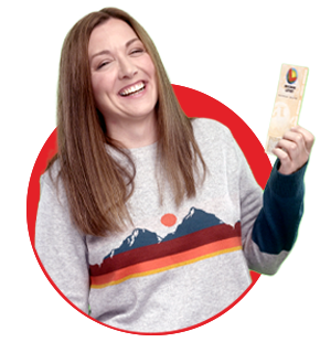 smiling wisconsin lottery winner in grey sweater with long brown hair holding up winning ticket on red circle background